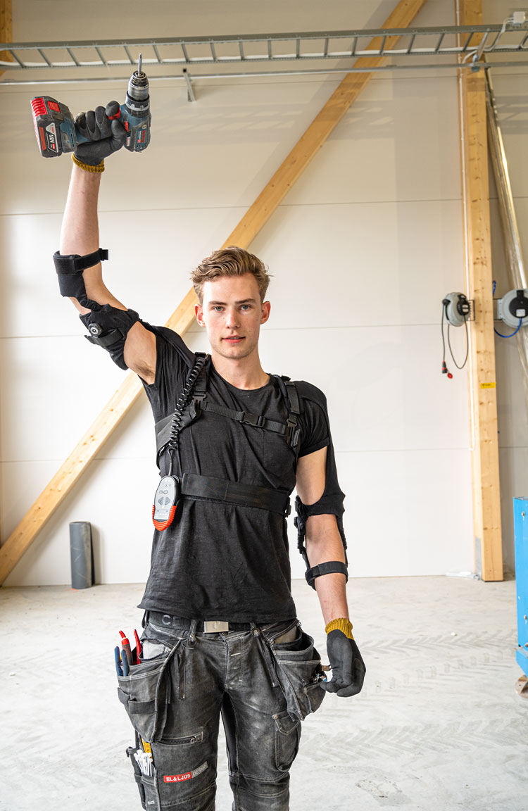 Kille med exoskelett och borrmaskin