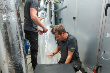 Mattias Asplund och Jimmy Jönsson gör den sista kopplingen till Aerosealmaskinen. Foto: Daniel Roos